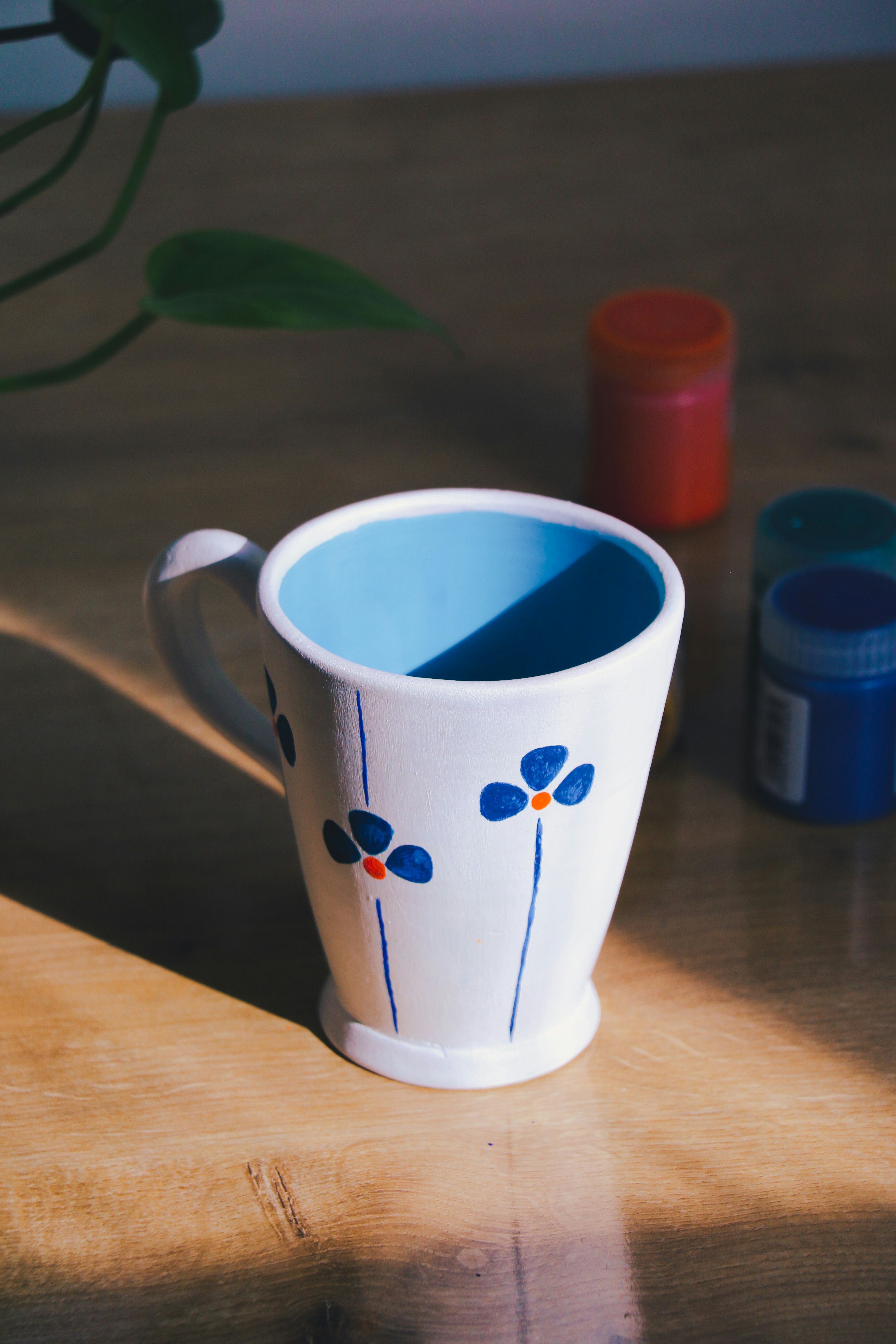 Set of nordic pastel ceramic mugs on light wooden table, airy Scandinavian interior