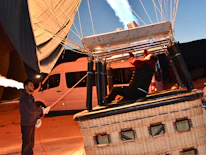 Close-up of a pilot preparing the hot air balloon for flight with a focused expression.