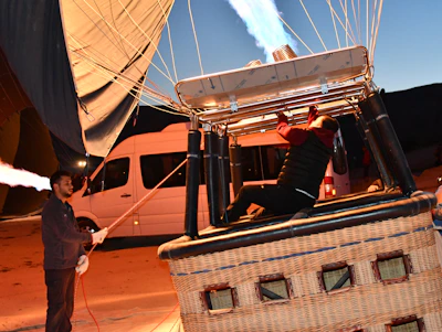 Close-up of a pilot preparing the hot air balloon for flight with a focused expression.