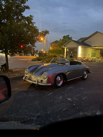 A sophisticated vintage car parked in an elegant European-style courtyard under soft muted lighting
