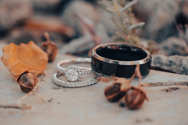 A flat lay of rings surrounded by natural elements like flowers.