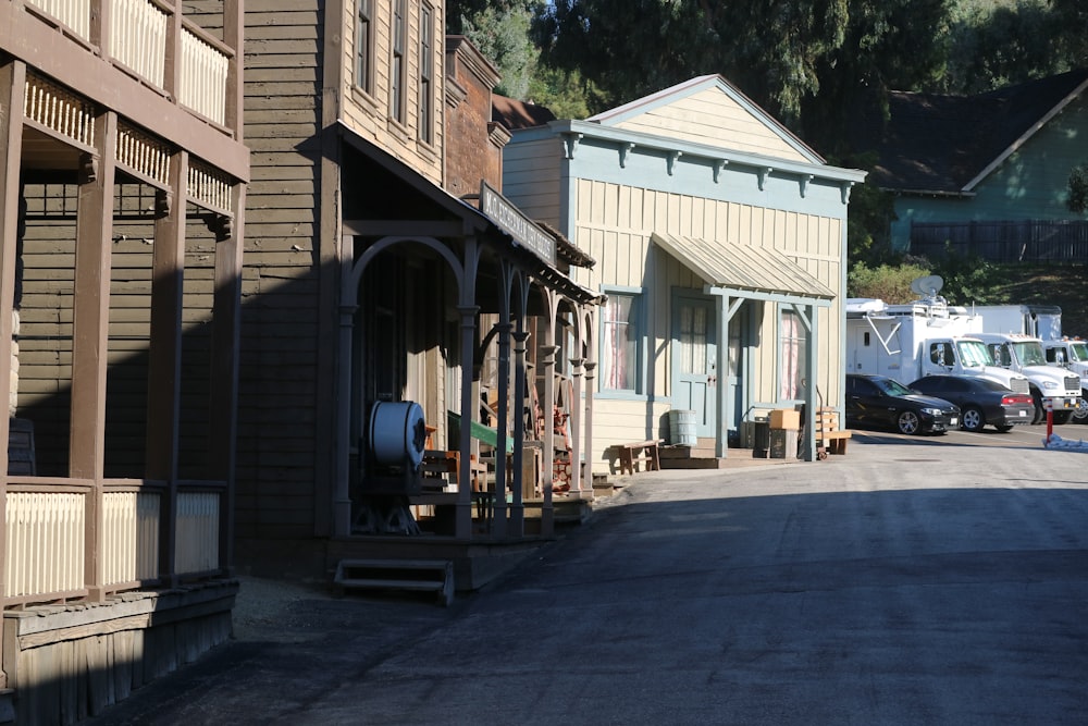 a street lined with wooden buildings and parked cars