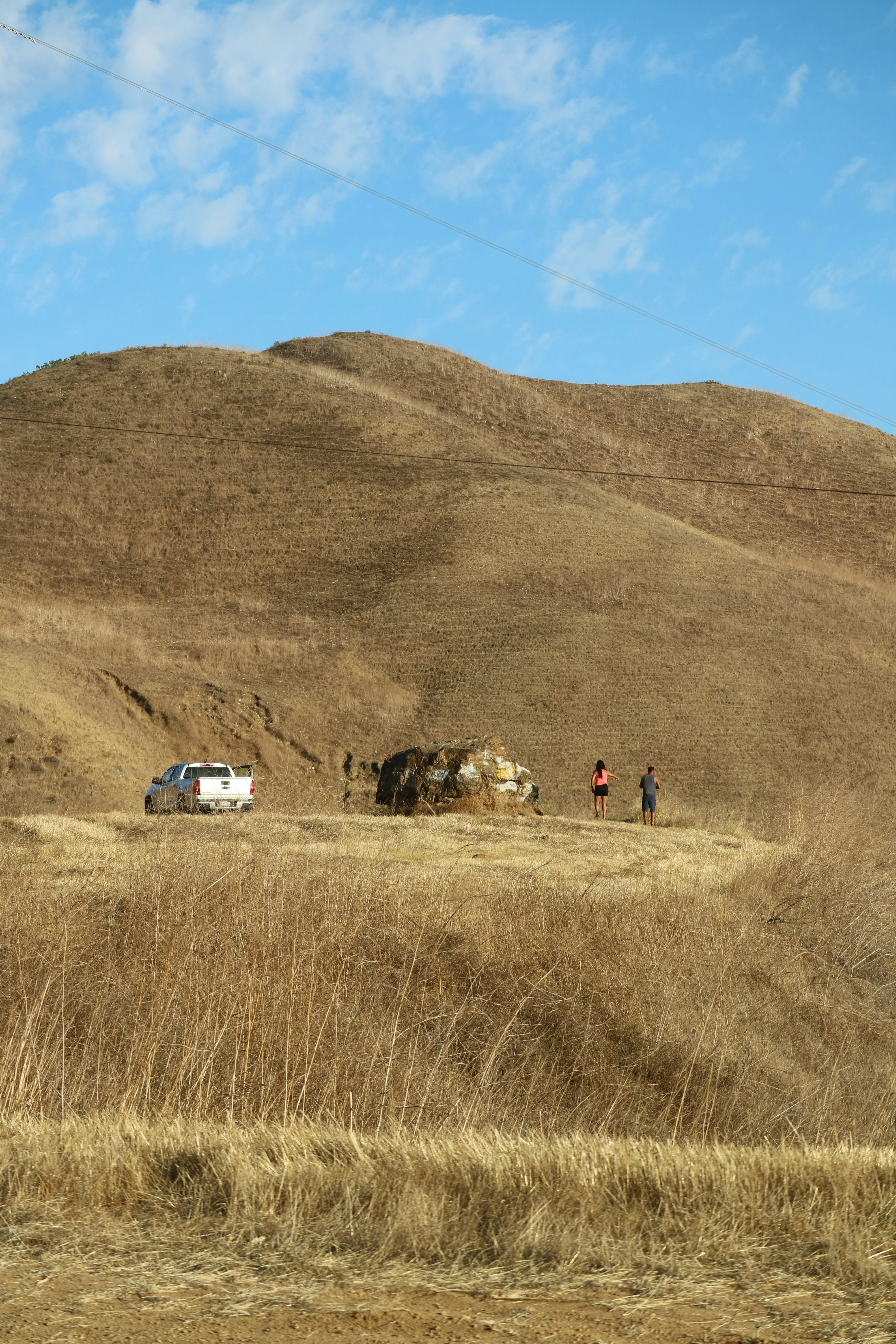 a group of people walking across a dry grass field