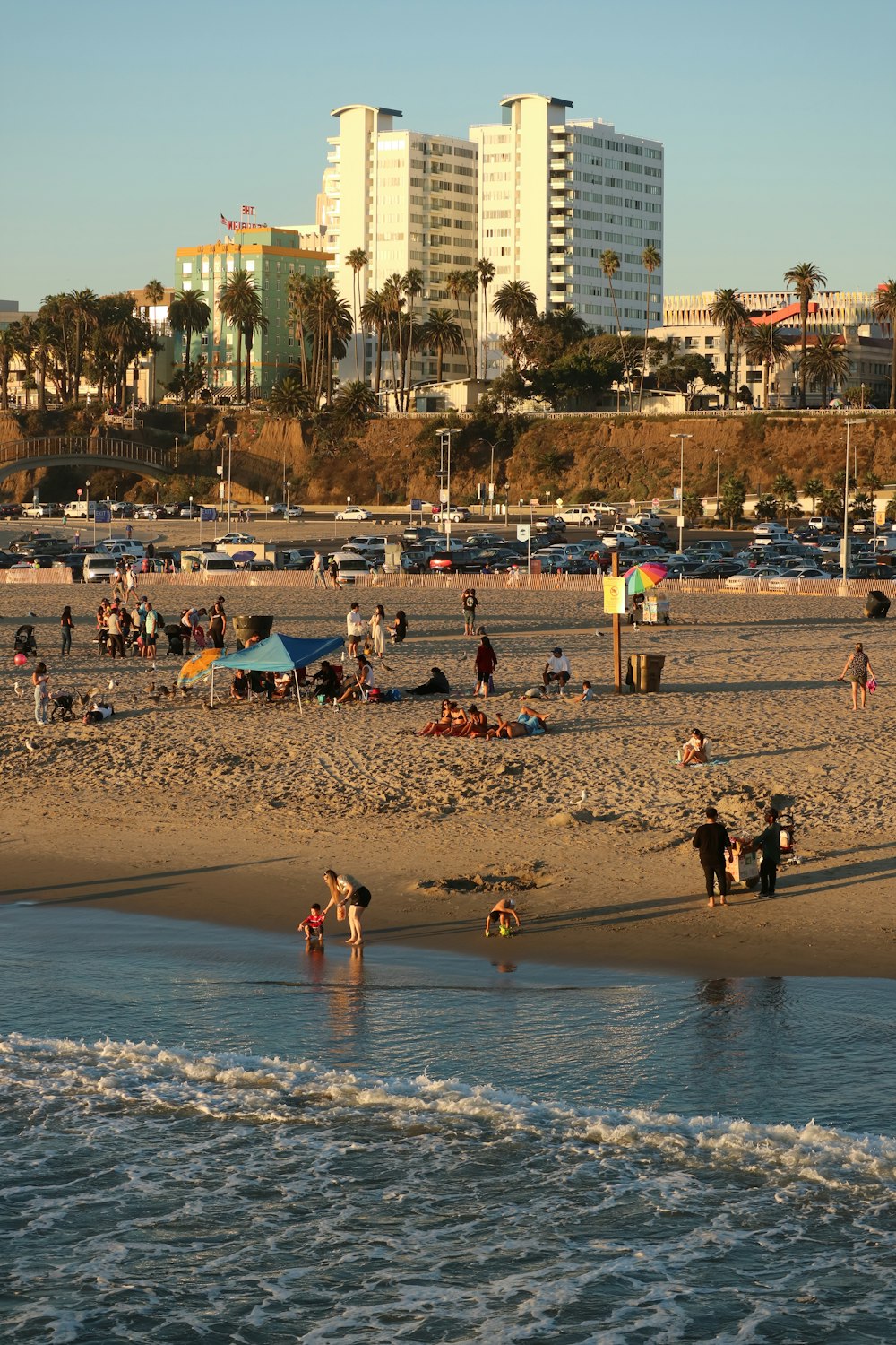 a beach with a lot of people and buildings in the background