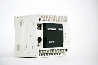 Compact PLC device with multiple input and output ports.