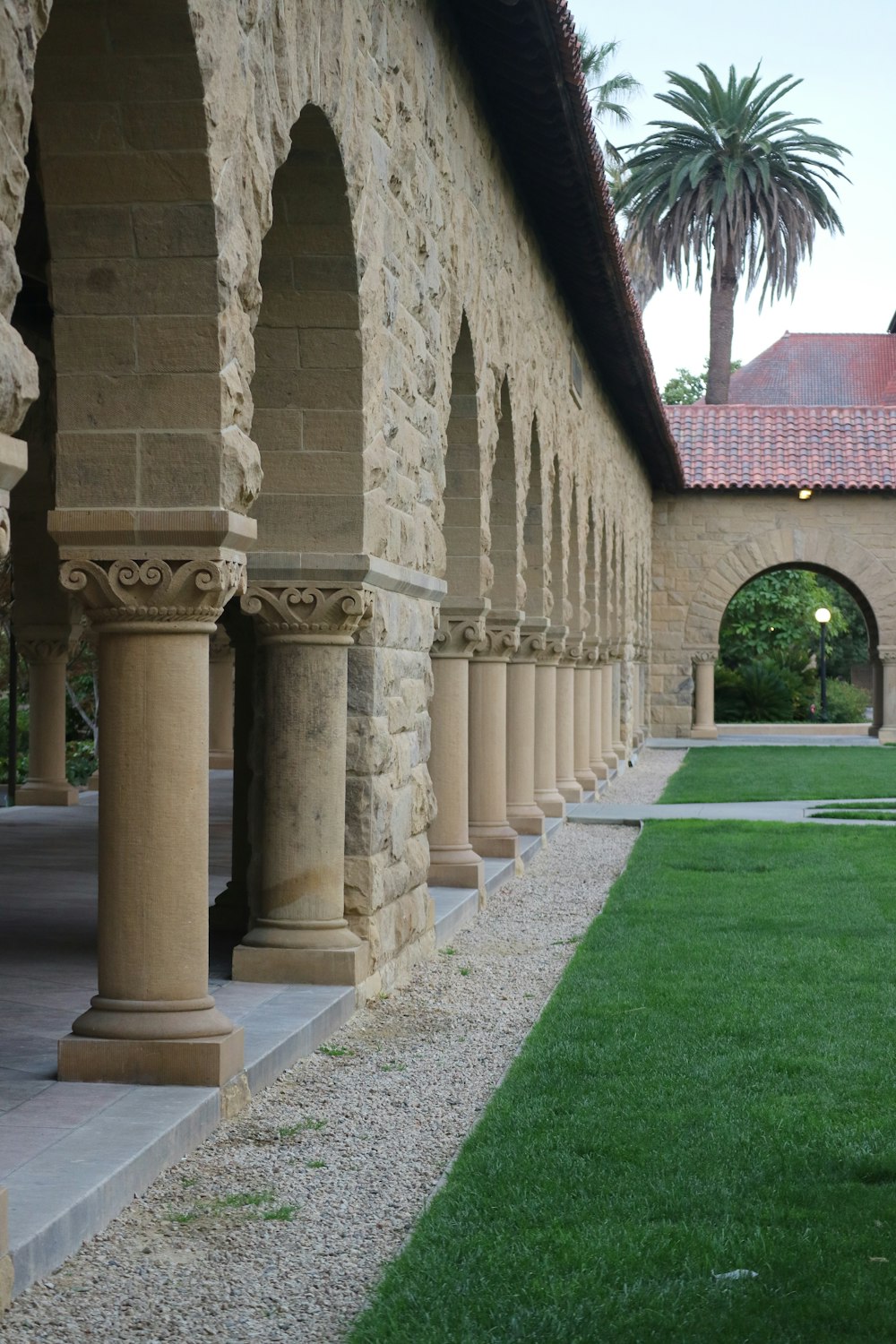 a long row of stone pillars next to a lush green field