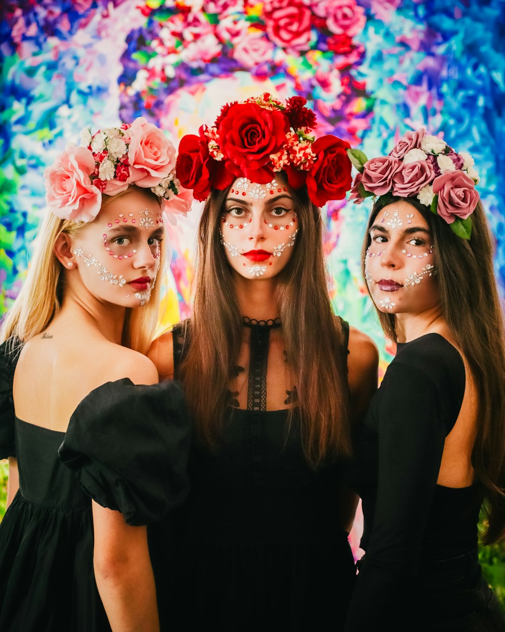 three women with face paint and flowers on their heads