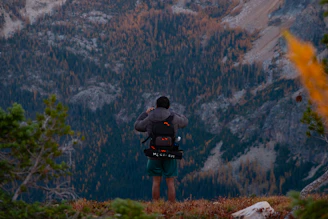 a man standing on top of a lush green hillside