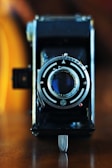 Close-up of a DSLR camera with a vintage lens on a wooden table.