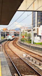 a train traveling down train tracks next to a tall building
