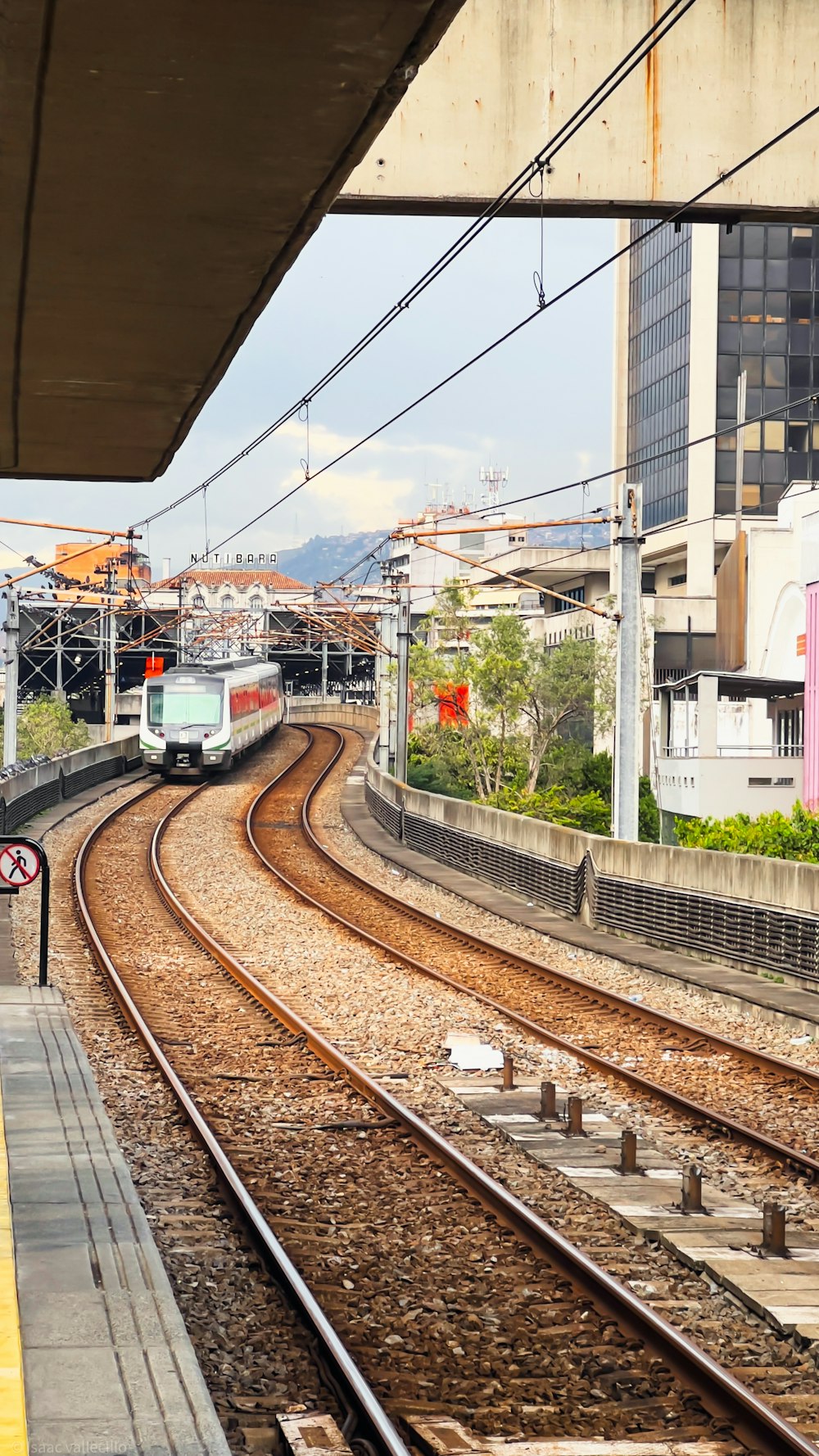 a train traveling down train tracks next to a tall building