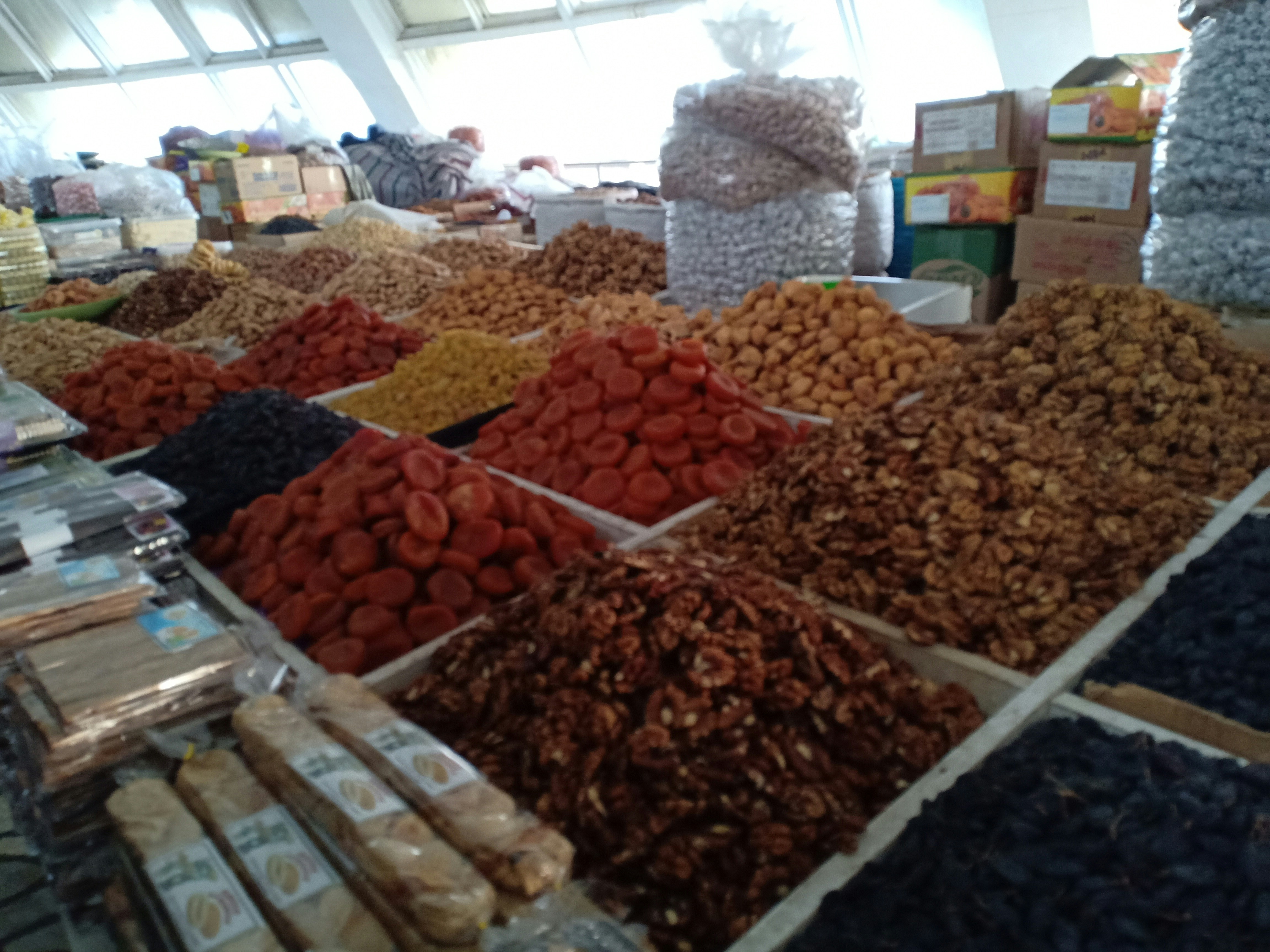 Assorted nuts and dried fruits in natural wooden bowls under bright airy natural lighting