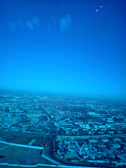 Aerial perspective of a city skyline under a clear blue sky.