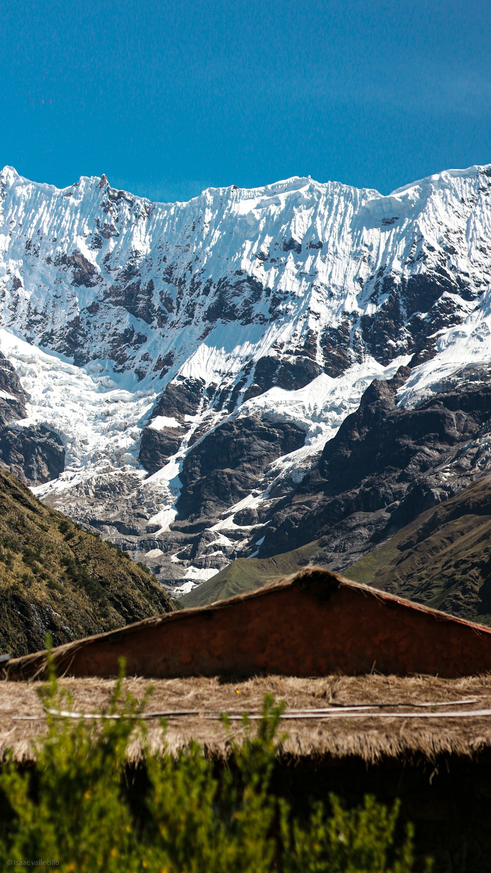 a view of a snowy mountain range with a hut in the foreground