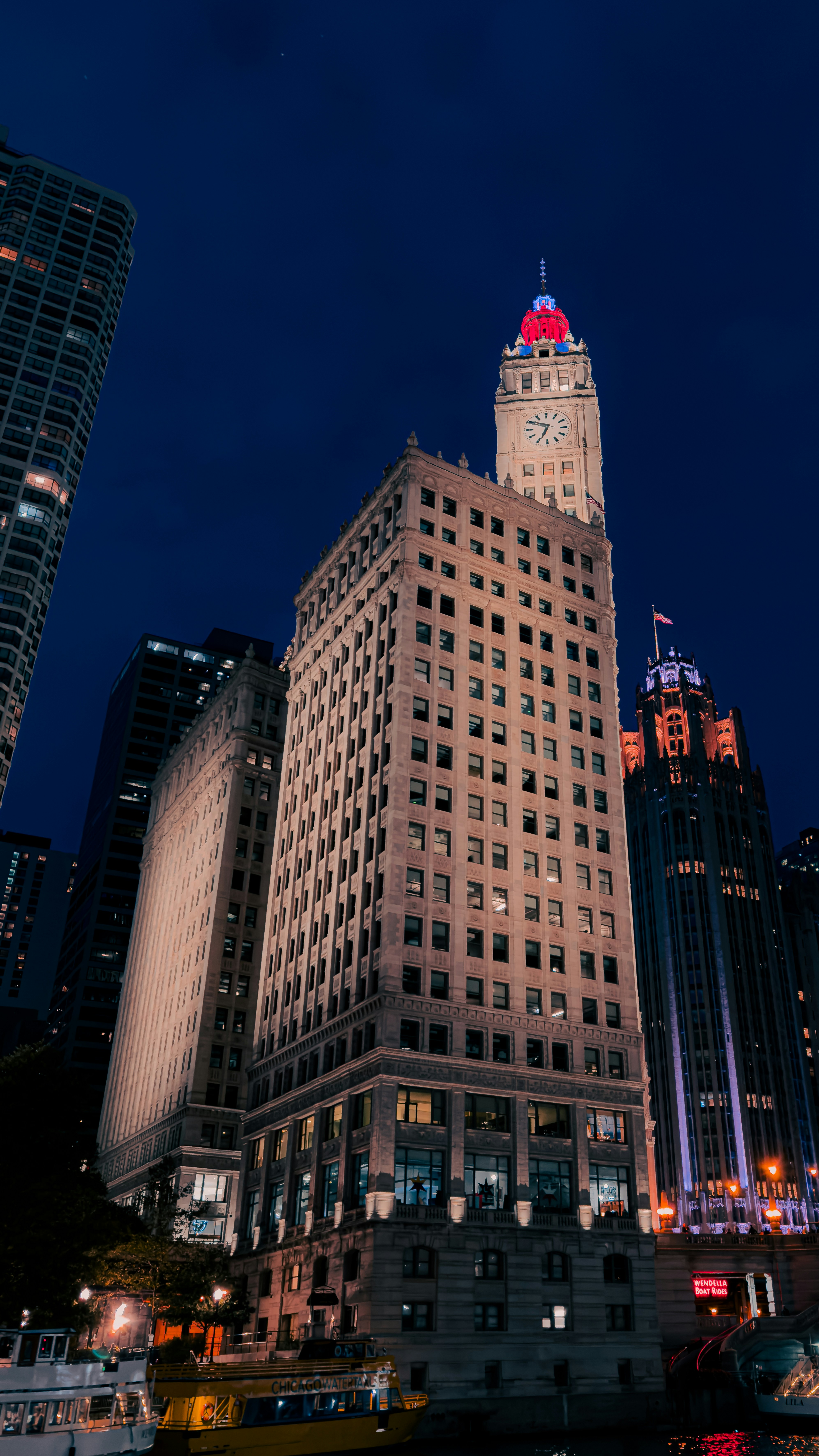 um edifício muito alto com uma torre do relógio à noite