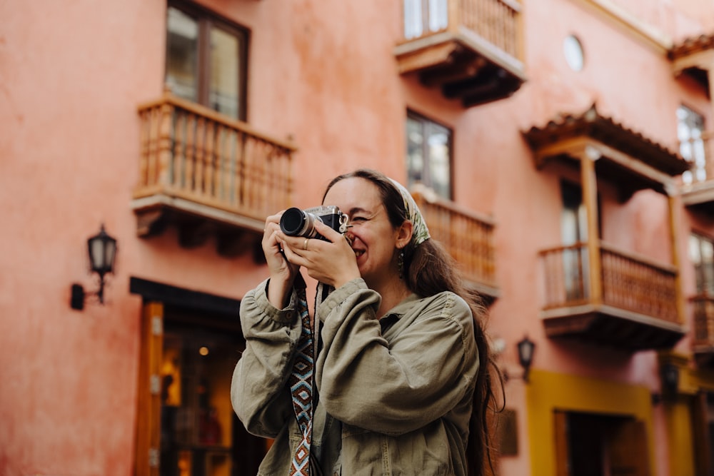 a woman taking a picture of a building with a camera