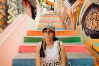 a woman sitting on the steps of a colorful staircase