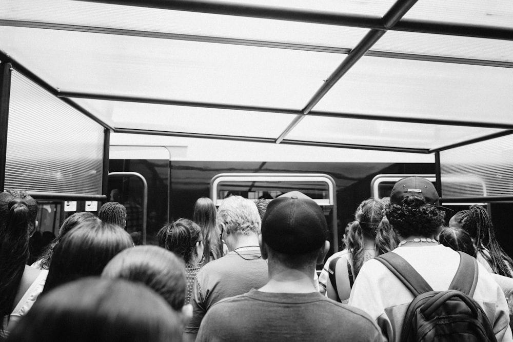 a black and white photo of a group of people on a subway