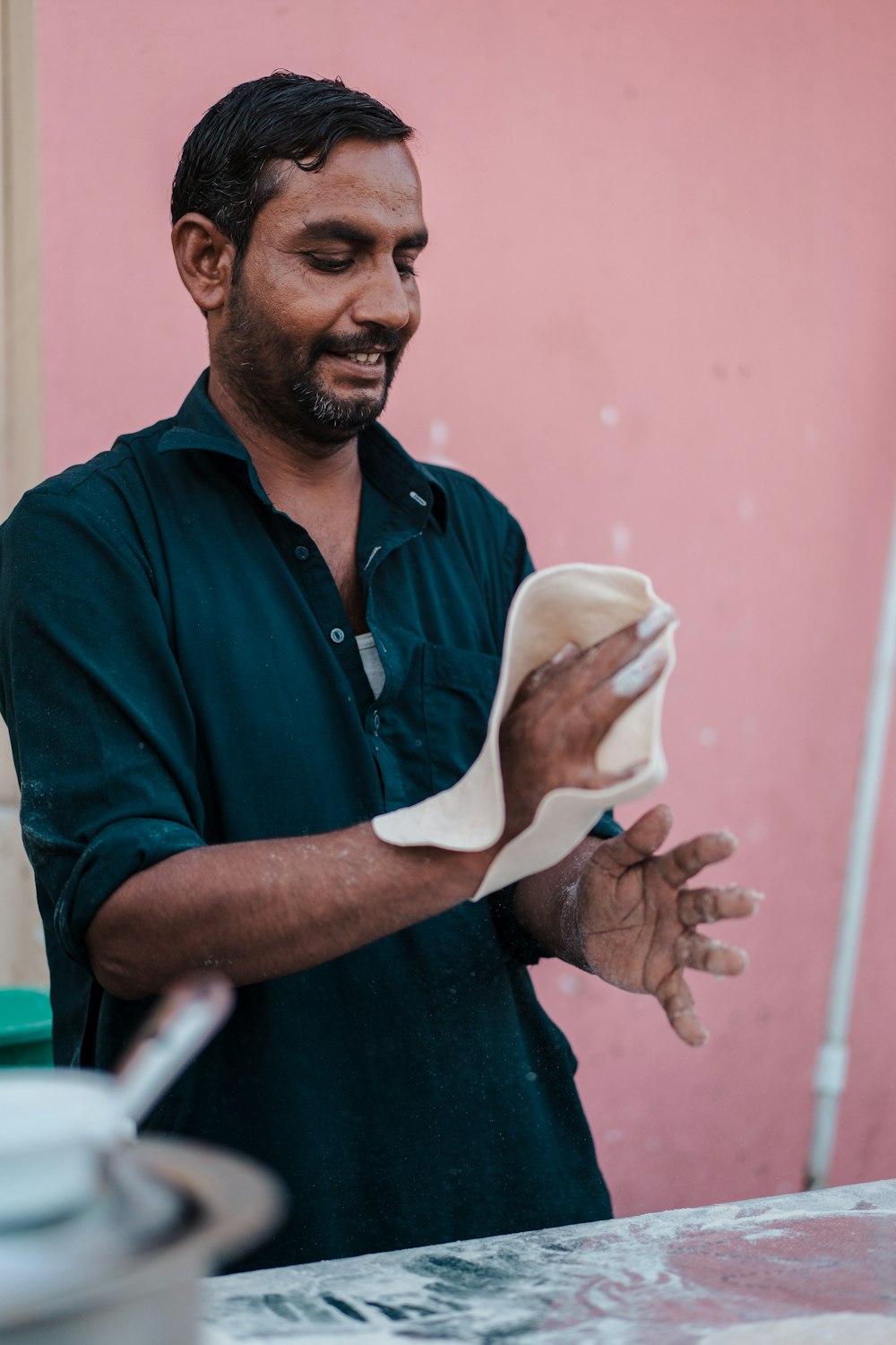 a man holding a napkin in front of a pink wall