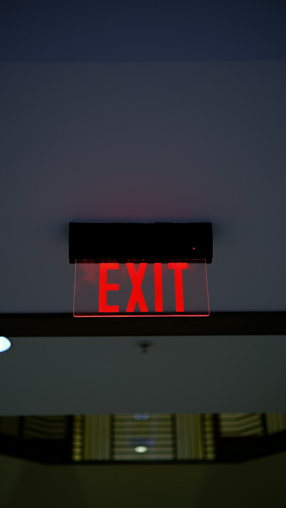 a red exit sign hanging from the ceiling