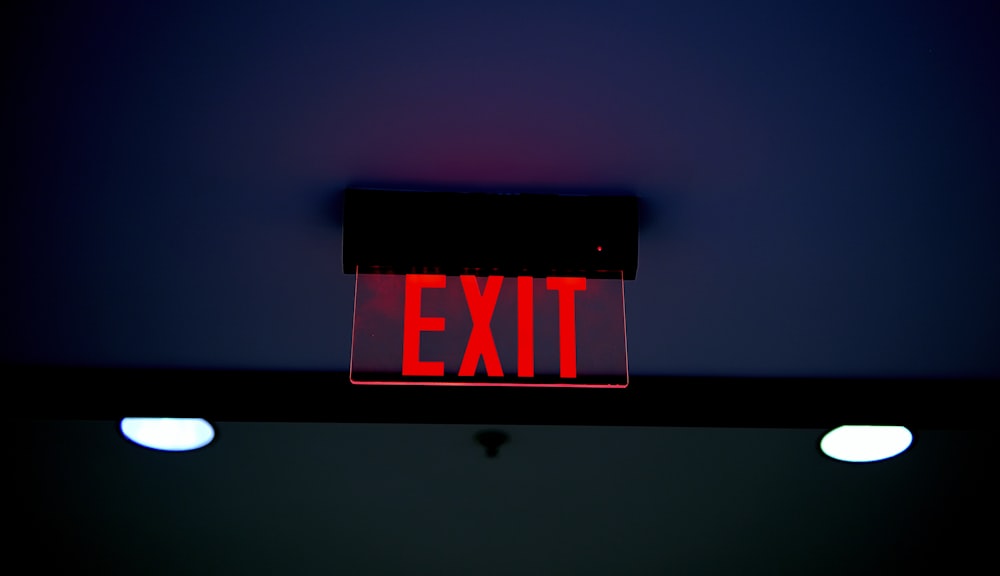 a red exit sign is lit up in the dark