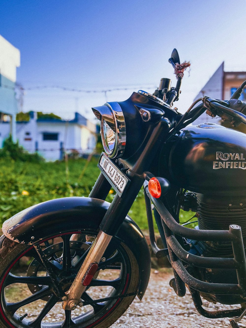 a black motorcycle parked on top of a gravel road