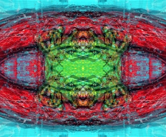 An abstract digital artwork featuring intricate patterns and vibrant colors. The composition displays a symmetrical design with a central green area surrounded by vivid reds and blues. The image includes textural elements that add depth and complexity.