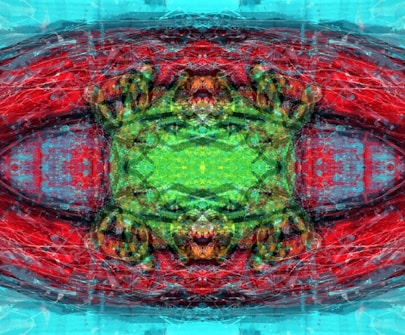 An abstract digital artwork featuring intricate patterns and vibrant colors. The composition displays a symmetrical design with a central green area surrounded by vivid reds and blues. The image includes textural elements that add depth and complexity.