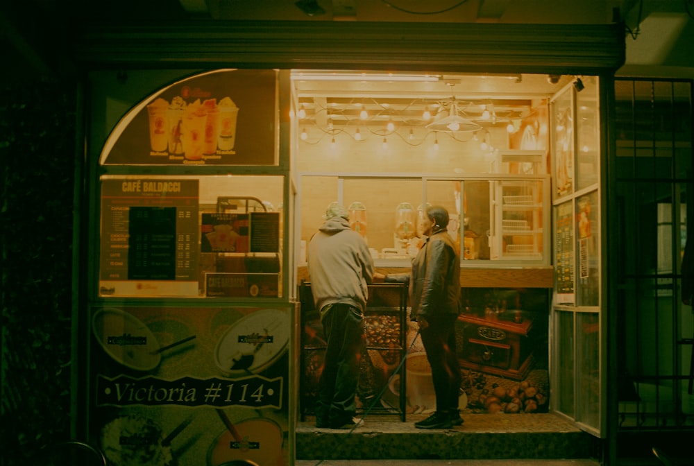 a couple of men standing in front of a vending machine