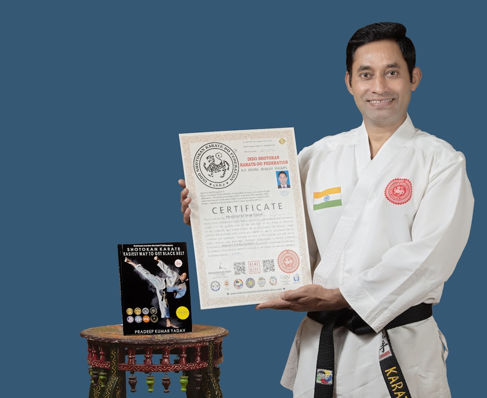 a man holding up a certificate next to a table