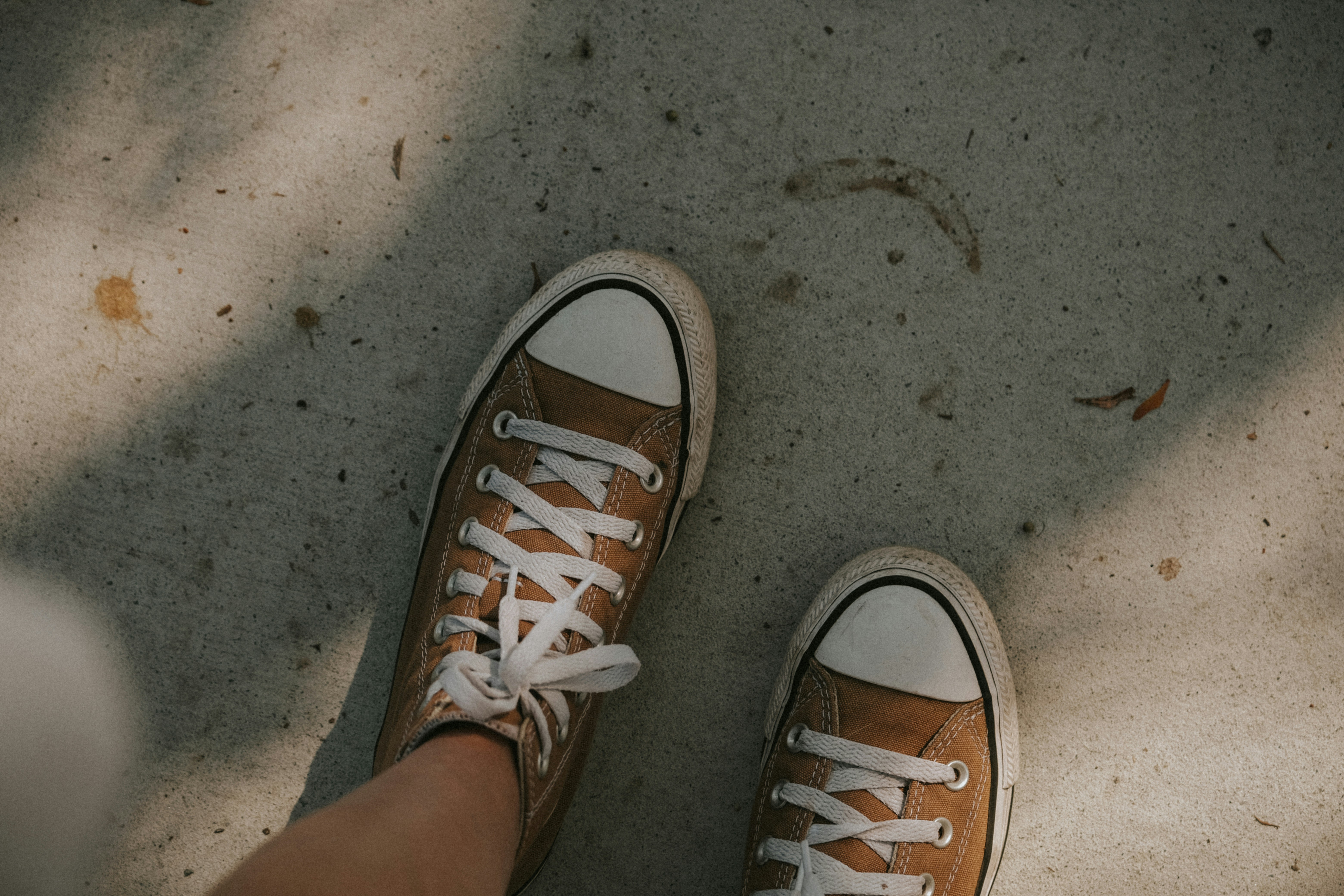 a person's feet wearing brown and white tennis shoes