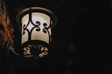 Close-up of a metal wall sconce casting soft light on a textured wall.