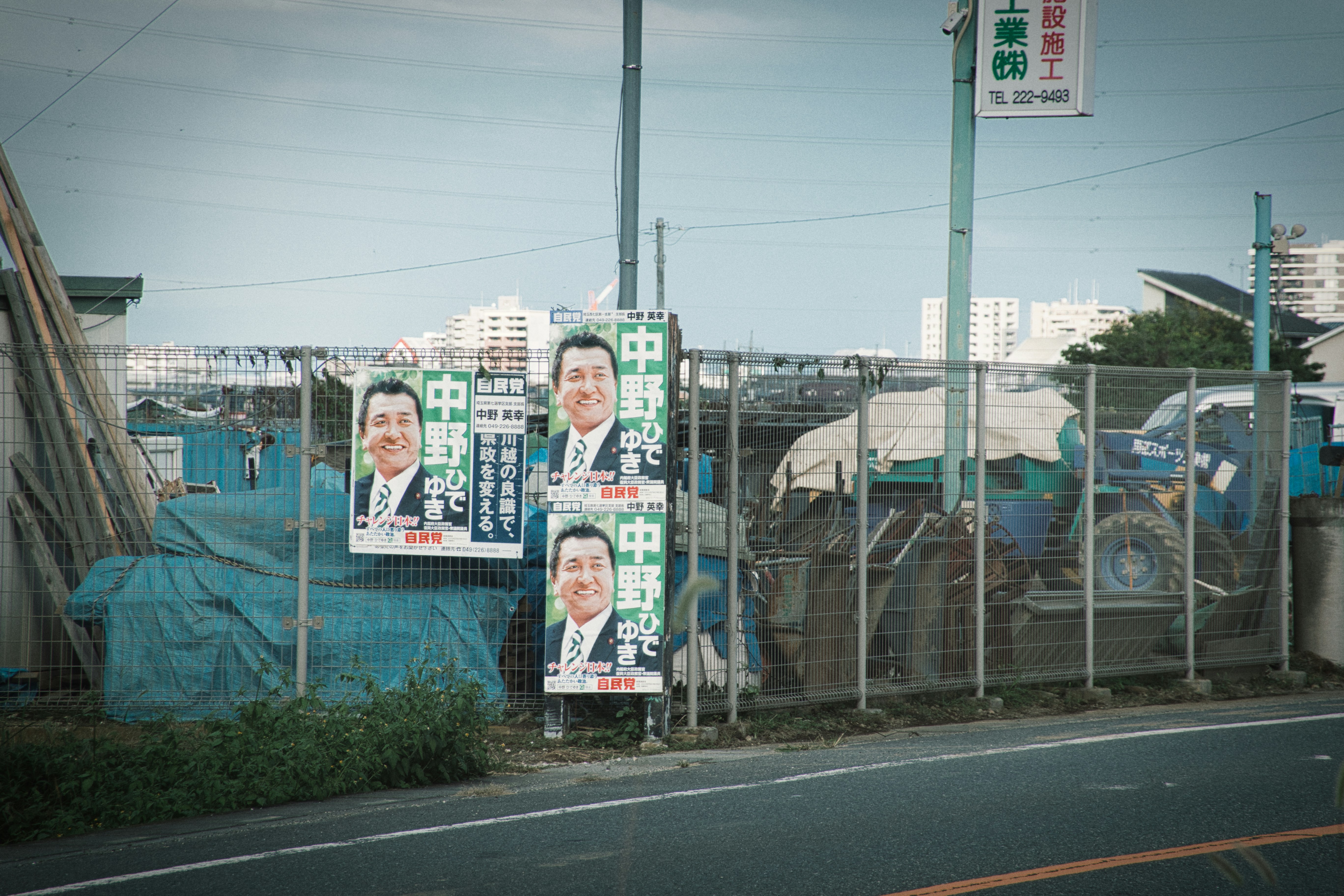 a fence with a bunch of political posters on it