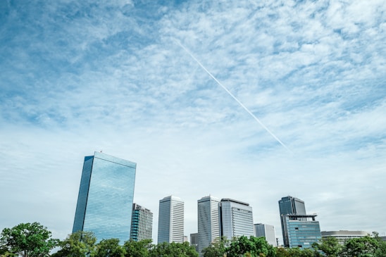 a plane flying in the sky over a city