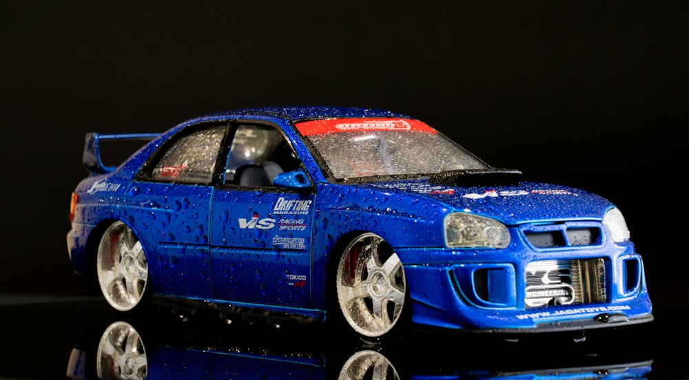 a blue toy car on a reflective surface