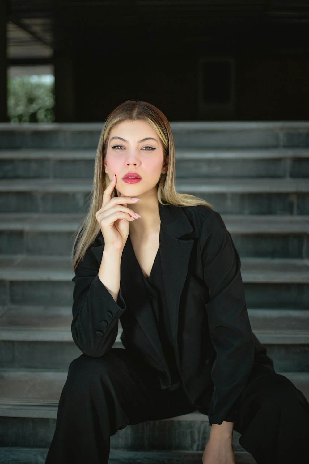 a woman sitting on steps with her hand on her chin