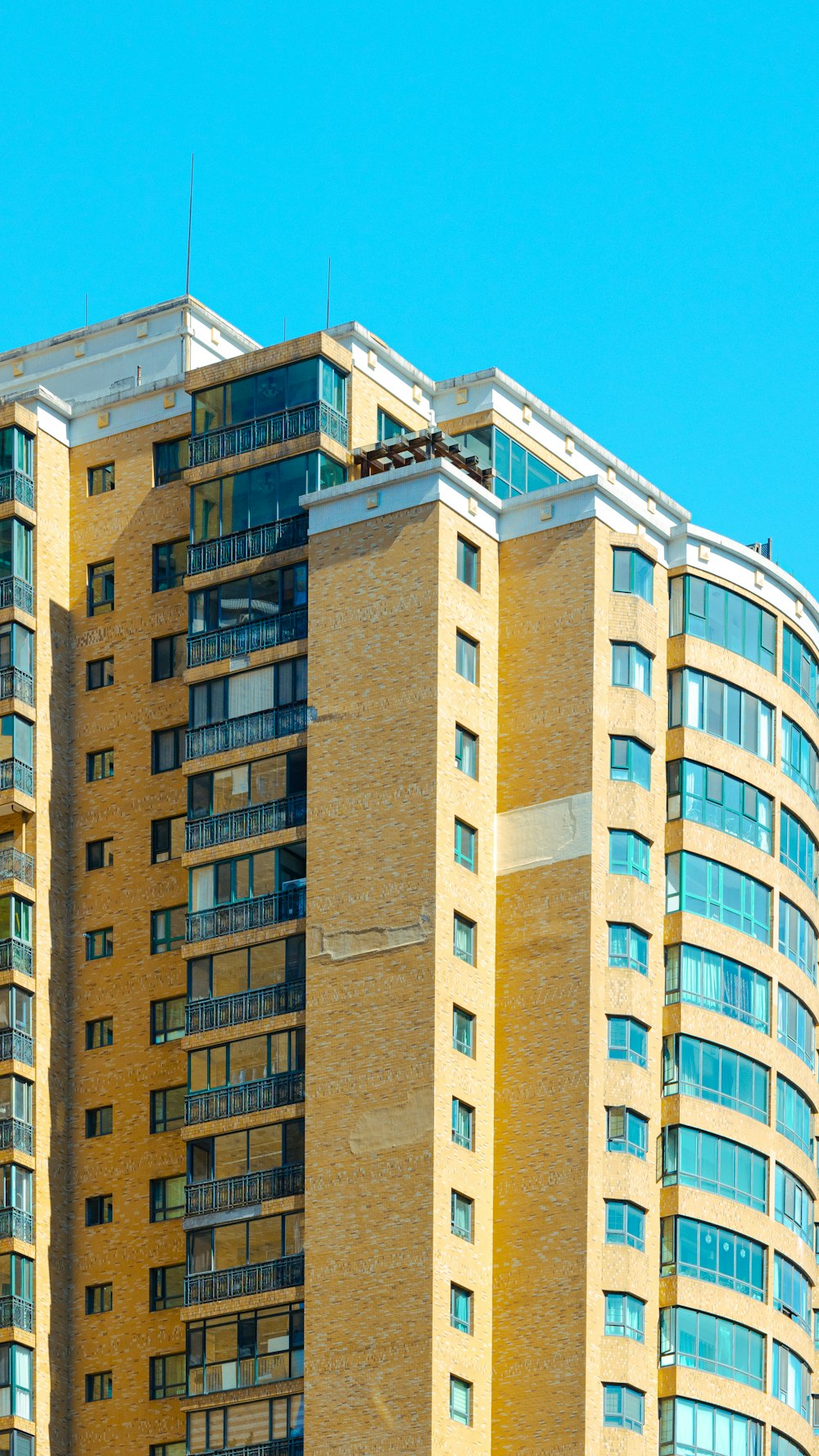 a tall yellow building with balconies and balconies on top