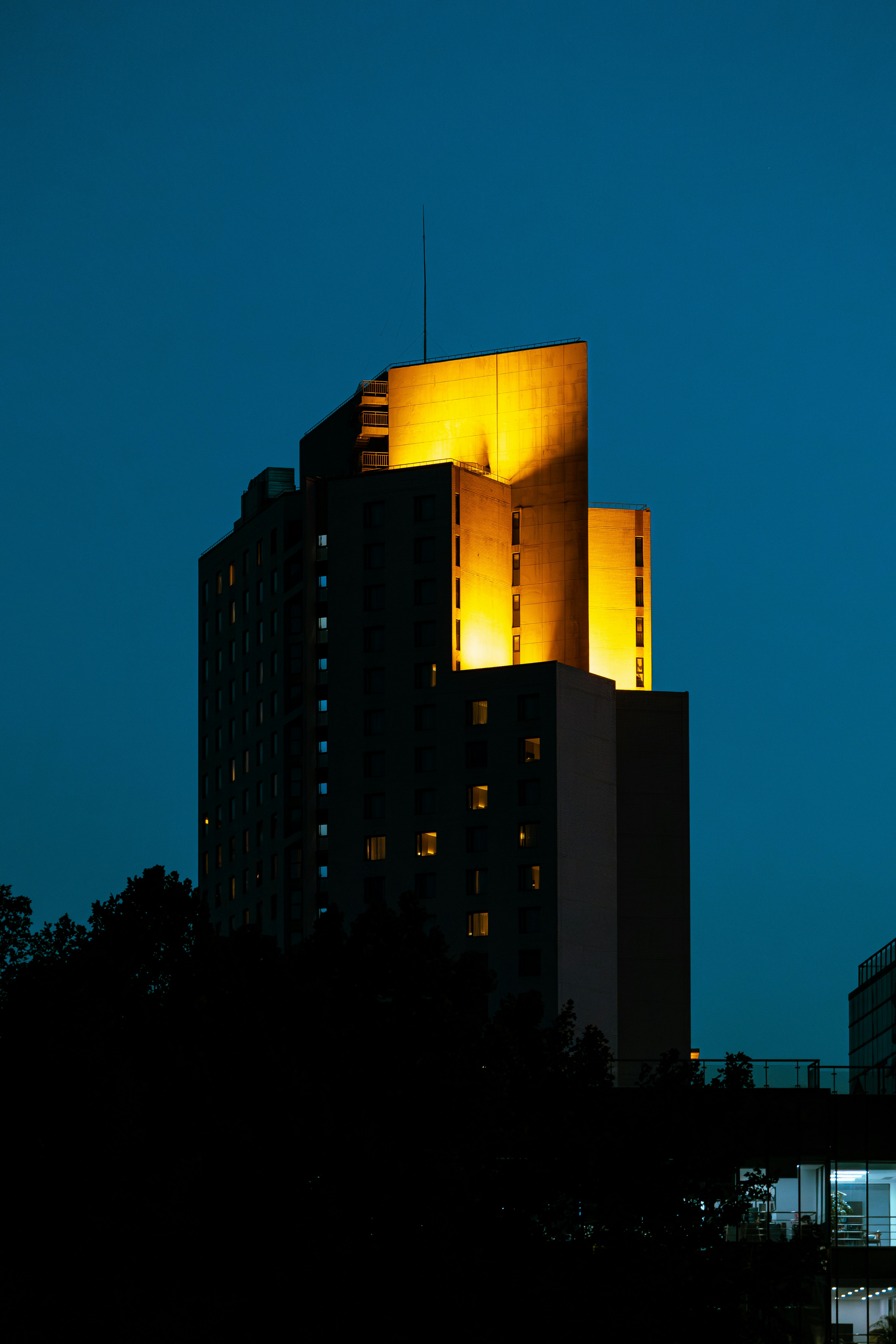a tall building lit up at night with a sky background