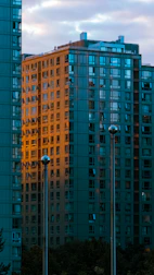 Modern real estate buildings with a golden sunset backdrop.