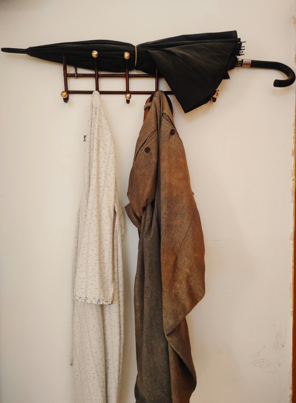 a coat rack with umbrellas hanging on it