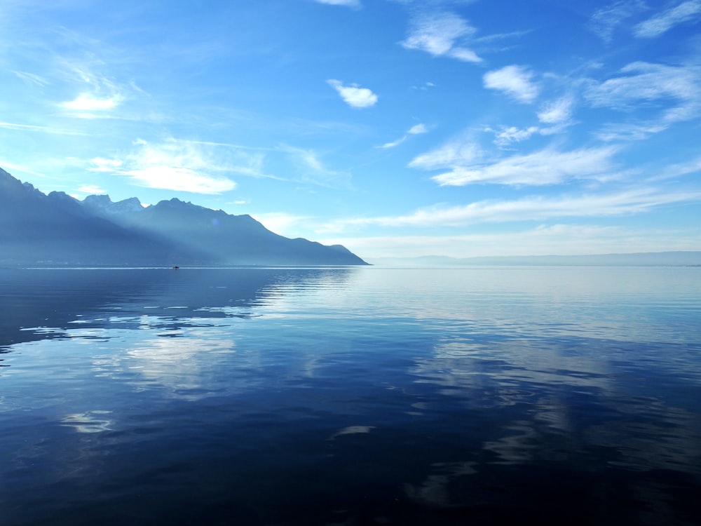 a large body of water with mountains in the background