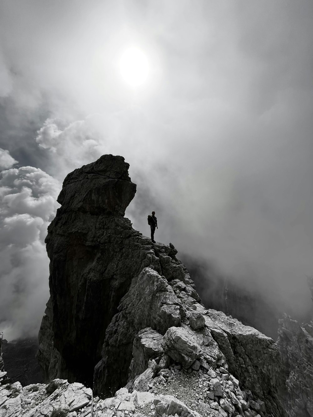 una persona de pie en la cima de una montaña rocosa