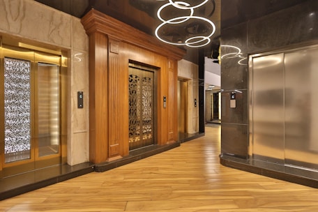 Modern elevator cabin with sleek false ceiling and stylish flooring design.