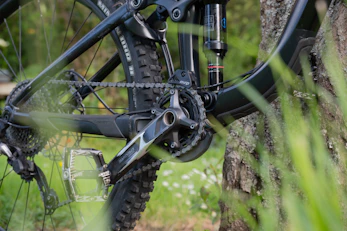 Close-up of mountain bike gears and accessories laid out on a wooden table.