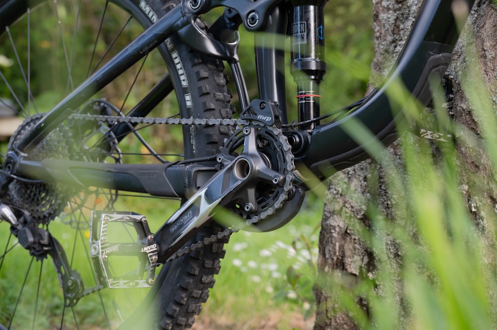 a close up of a bike parked next to a tree