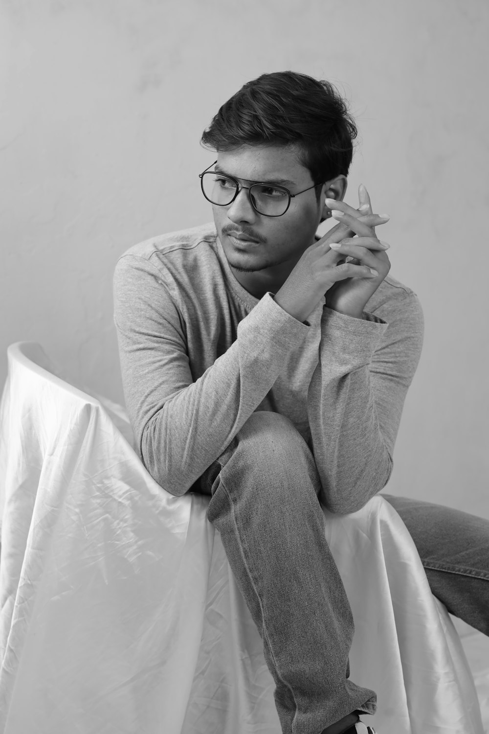 a man sitting on top of a bed holding a bottle