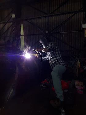 A welder working on a metal structure.