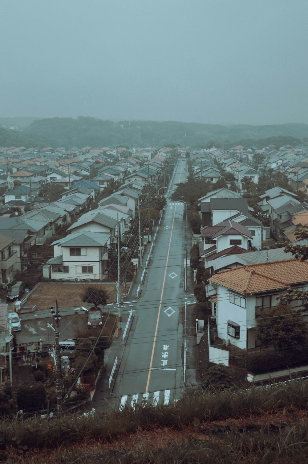 a view of a street with houses in the distance