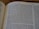 A page from a book titled 'The Books of the Prophets' is open, displaying bold text headers and several paragraphs of text. The page number is 649, and the text appears to be a religious or biblical passage. The background is a blurred wooden surface.