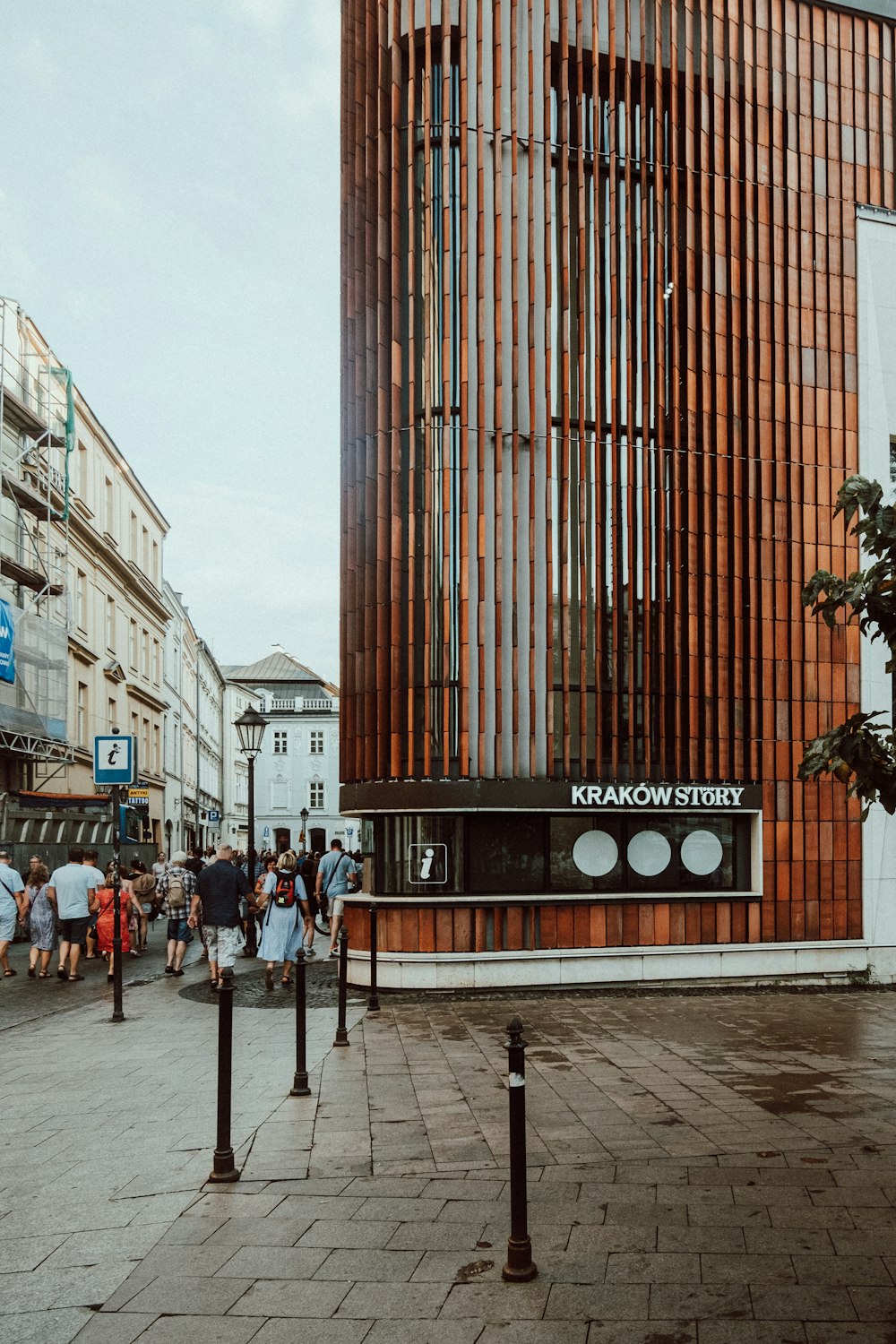 a group of people walking down a street next to tall buildings